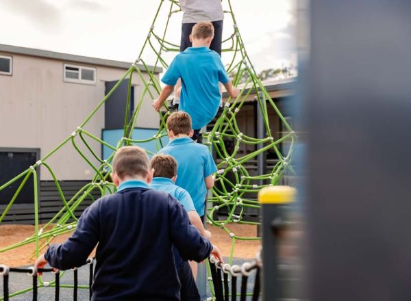 Students enjoying outdoor play equipment, fostering physical activity and social interaction.